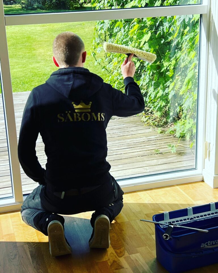 Strålande klara fönster. En av våra erfarna städare som putsar fönster hos en kund. Säboms - För en renare värld